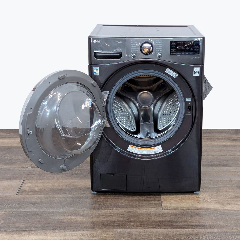 a washing machine with a door open on a wooden table.