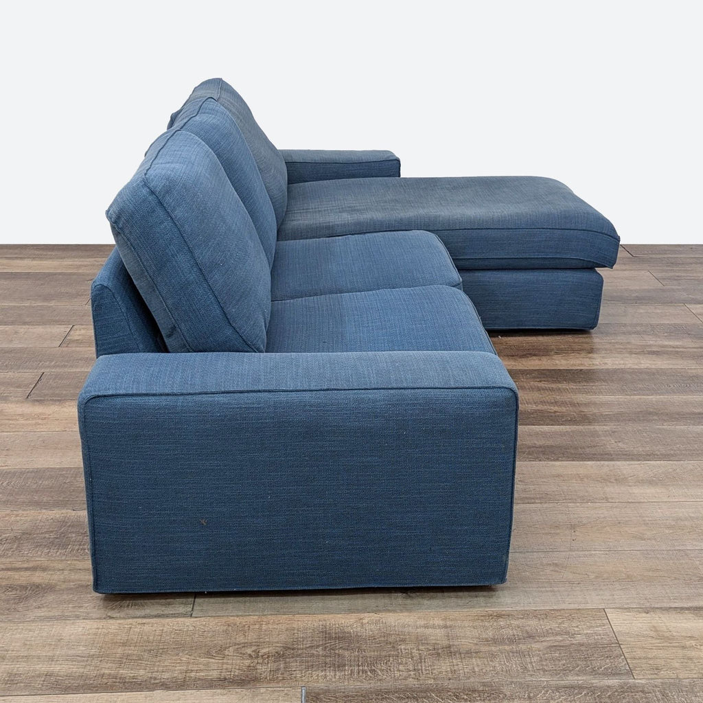 a pair of blue sofas and a matching ottoman