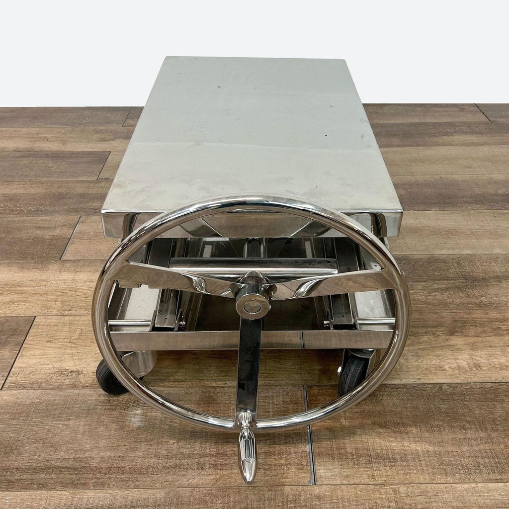 chrome coffee table with wheels and a chromed metal base.