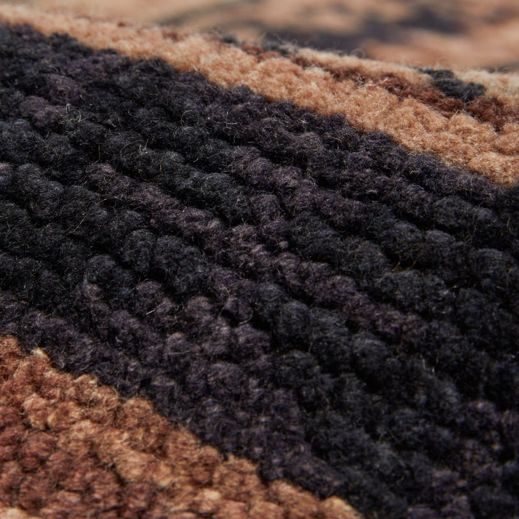 the texture of the carpet is brown, black, and brown.