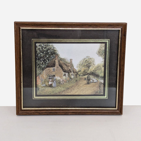 framed print of a cottage by a stream