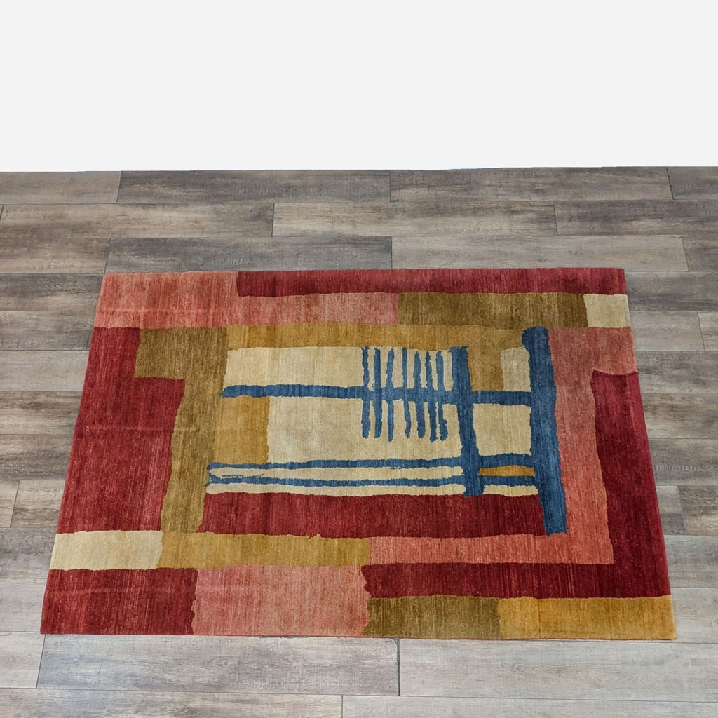 a red, yellow, and blue rug on a wooden floor.