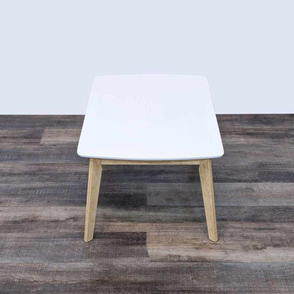 the square white table is a simple, modern design.