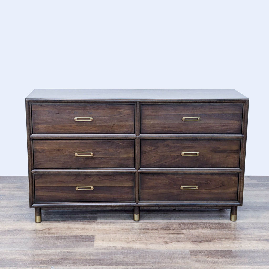 a large, dark wood dresser with a brass drawer pulls.