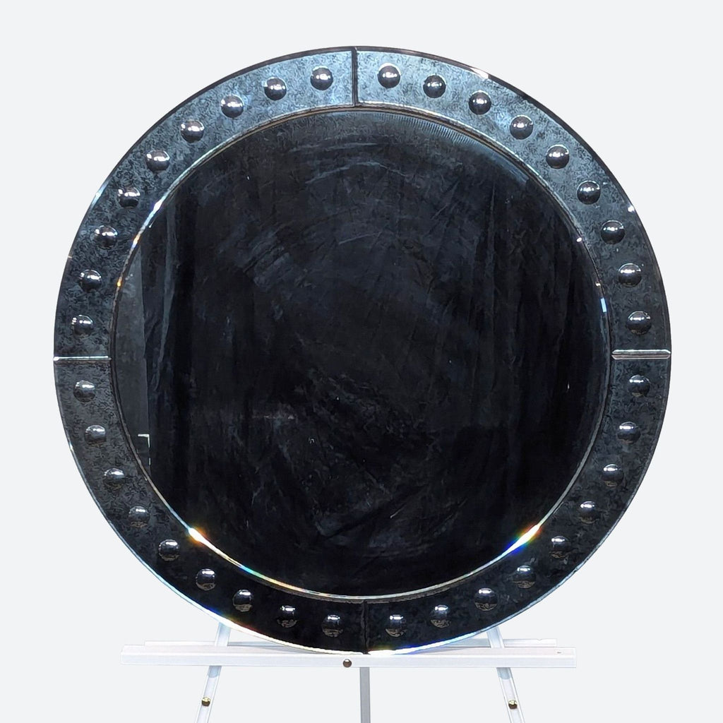 a large oval metal mirror with rivets