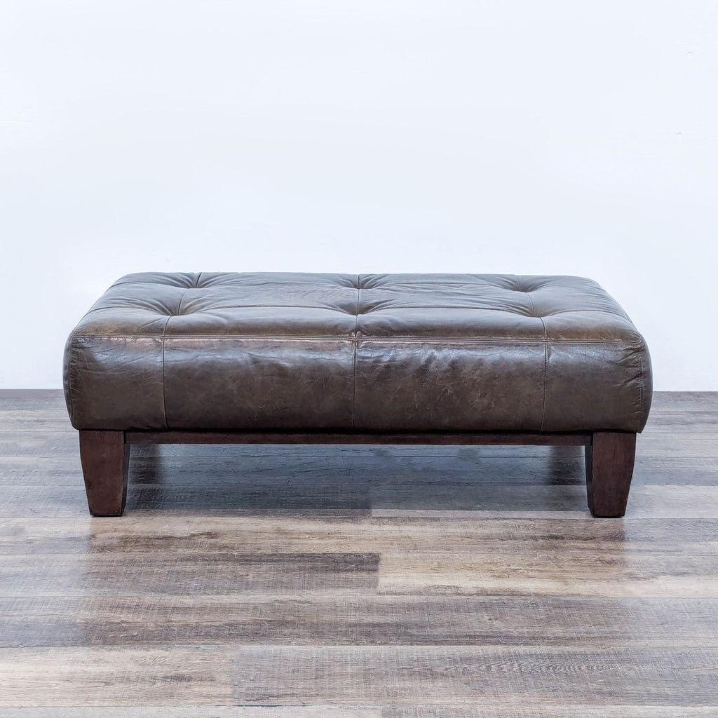 a brown leather ottoman from the 1970s.