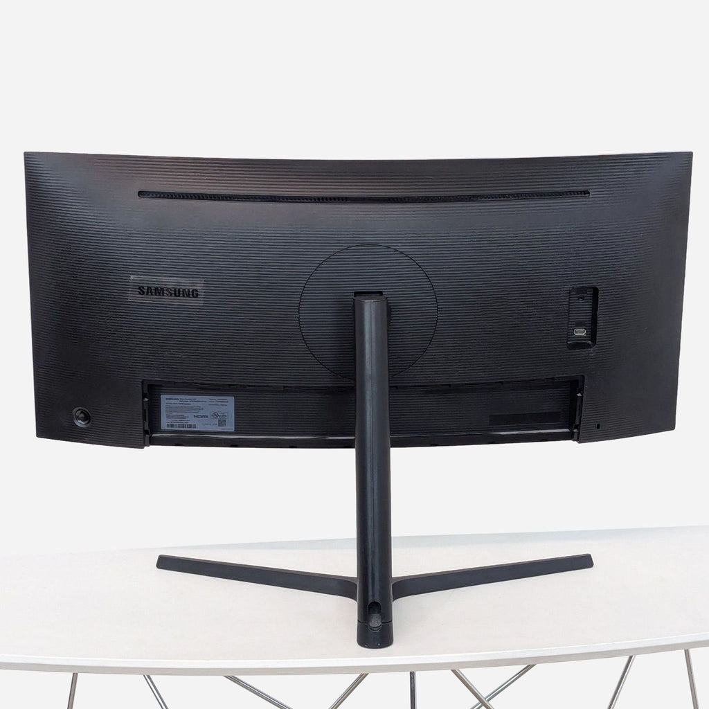 a large black monitor on a white table.