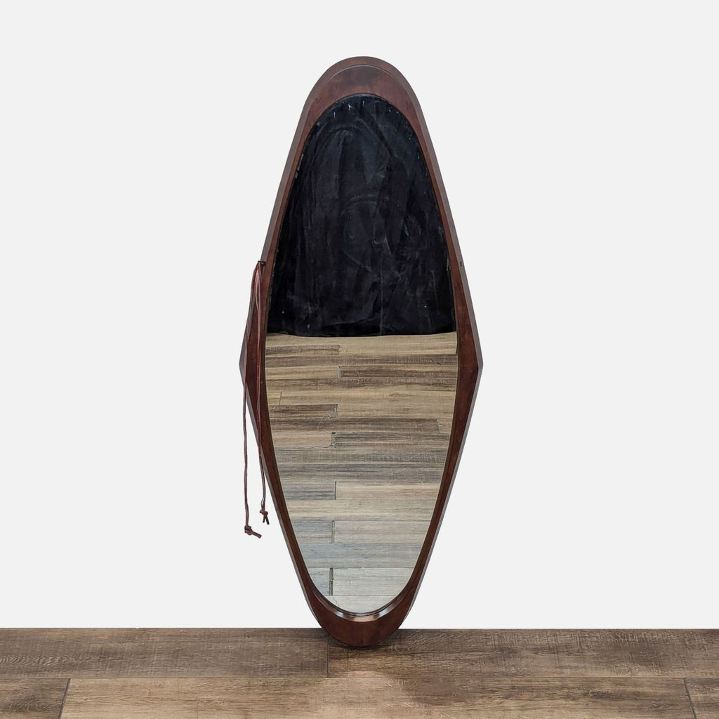 a mirror with a wooden frame and a leather seat.