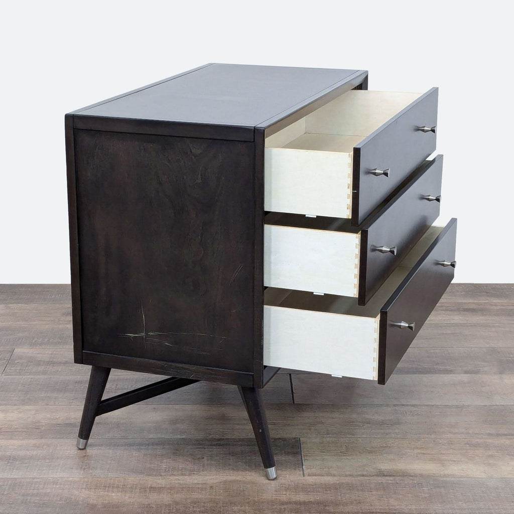 a vintage mid century modern dresser with drawers and a black metal base.