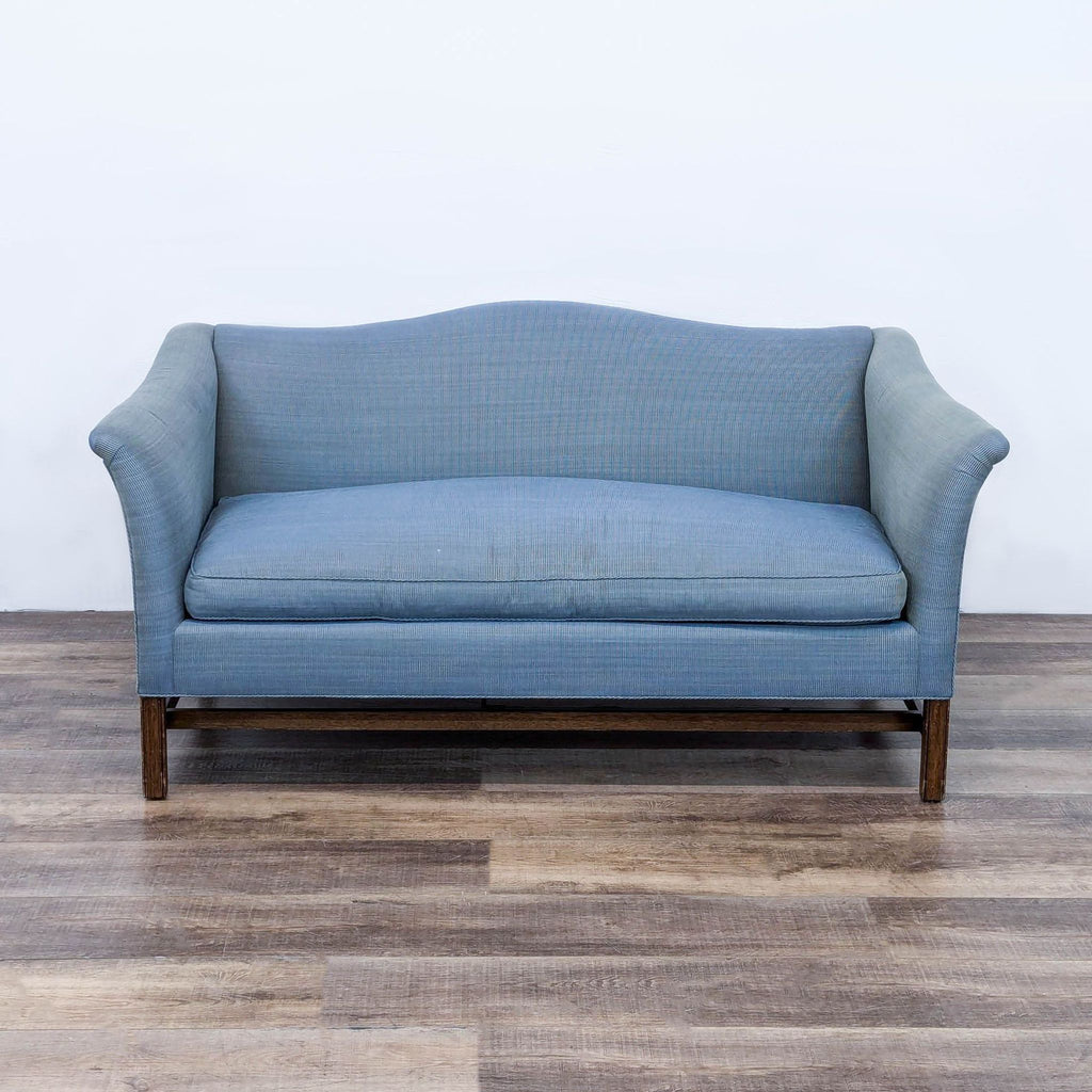 a blue sofa with a grey checkered back and a white back.