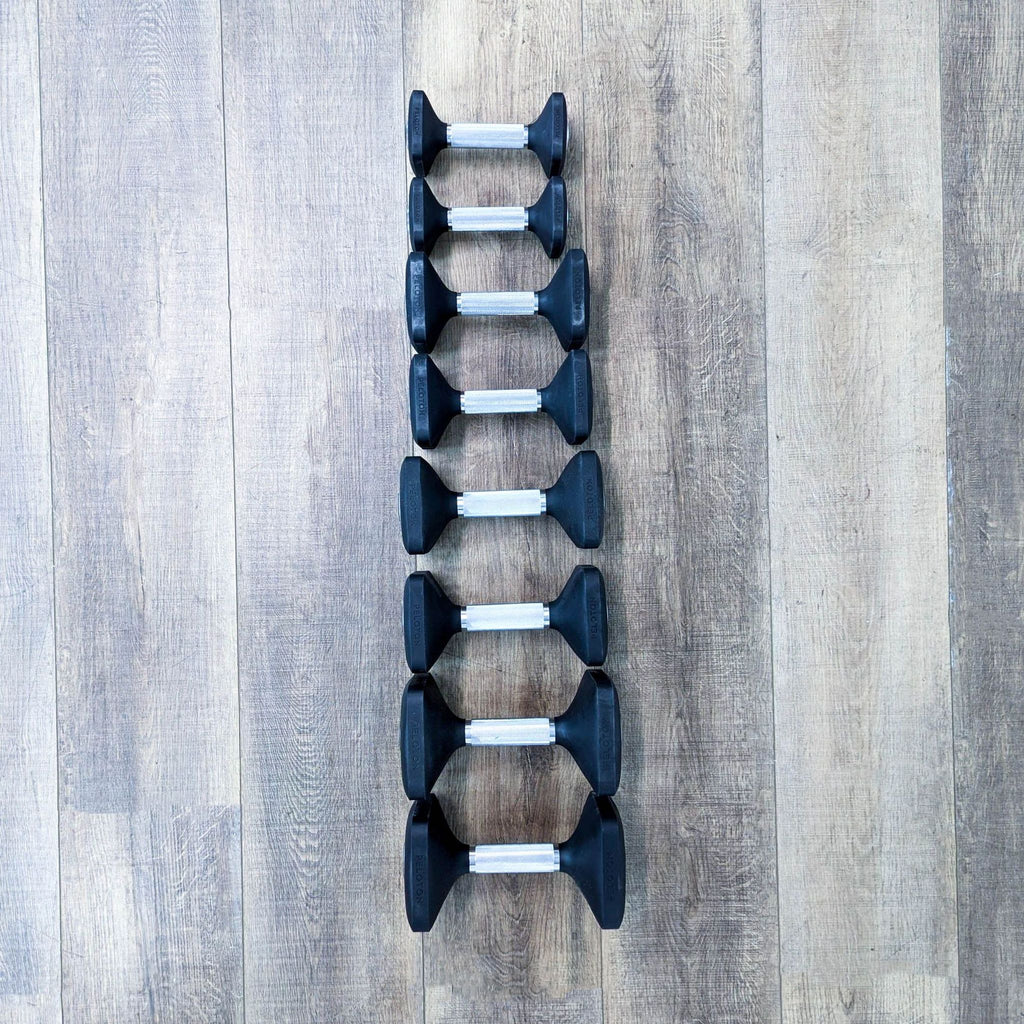 a set of 4 dumbbells on a wooden floor.