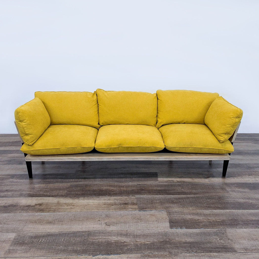 a yellow sofa with a black metal frame and a black metal frame.