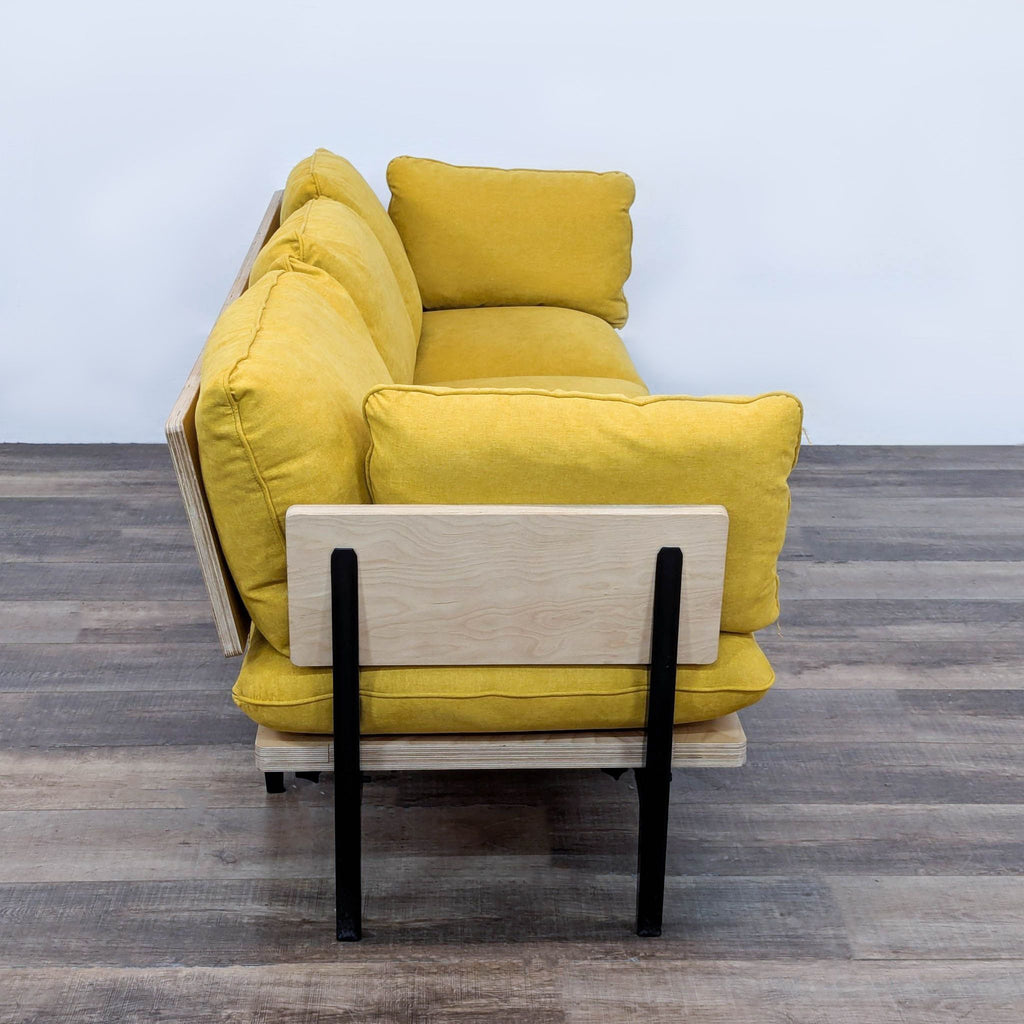 a yellow sofa with a black frame and a wooden frame.