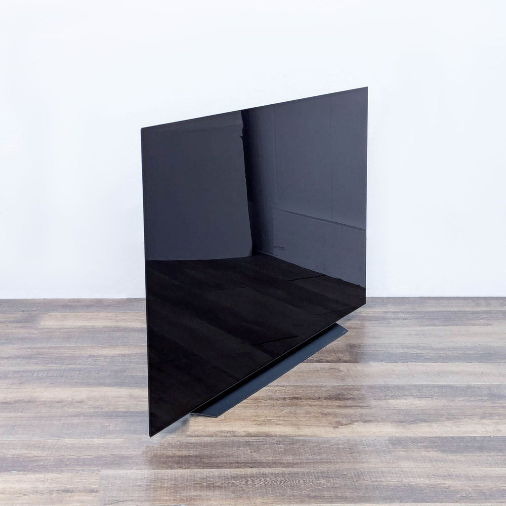 a black glass mirror with a black frame.