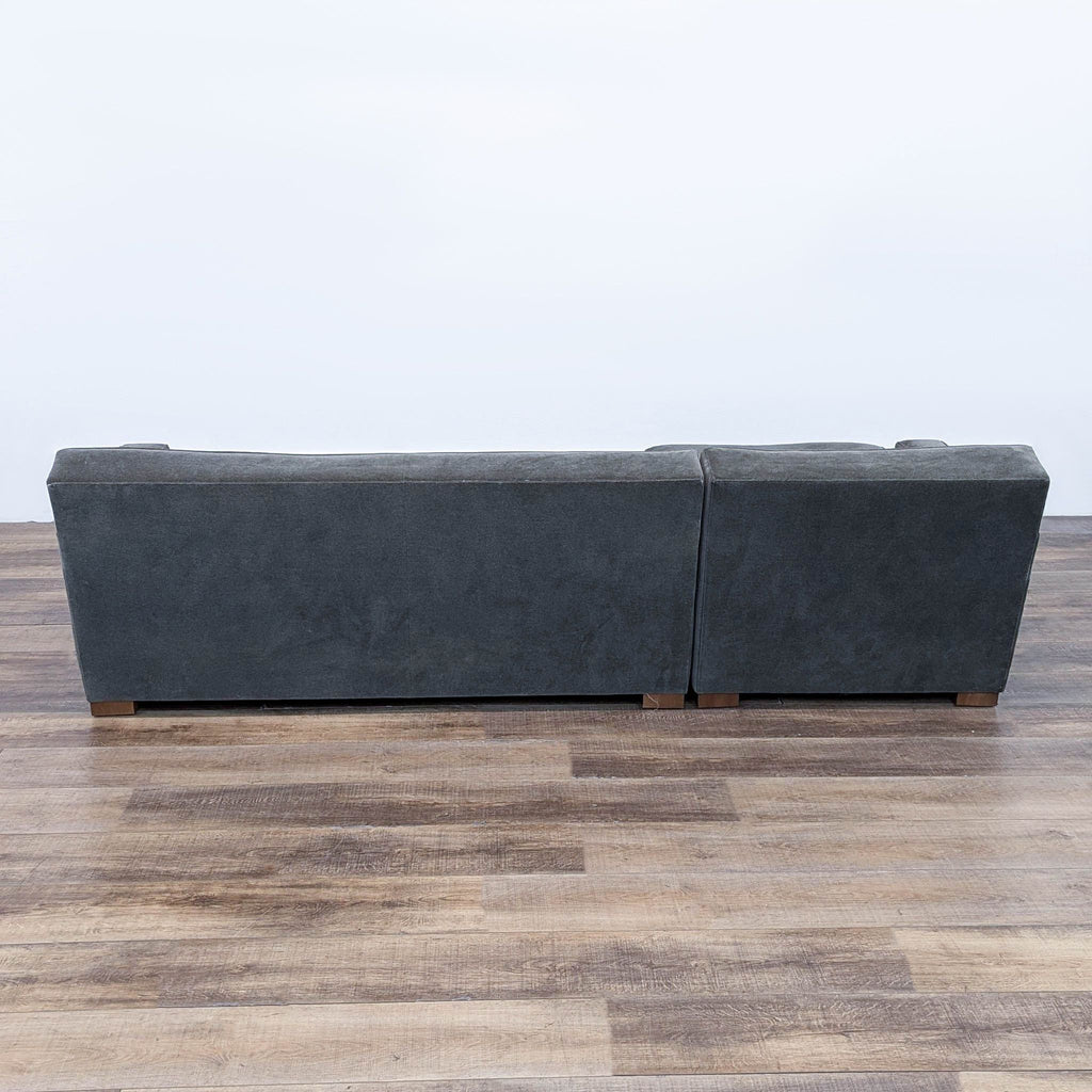 a grey leather sofa with a wooden base