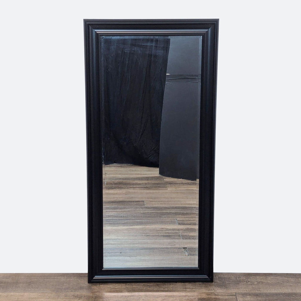 the mirror is made of a black frame with a black frame. the mirror is made of a