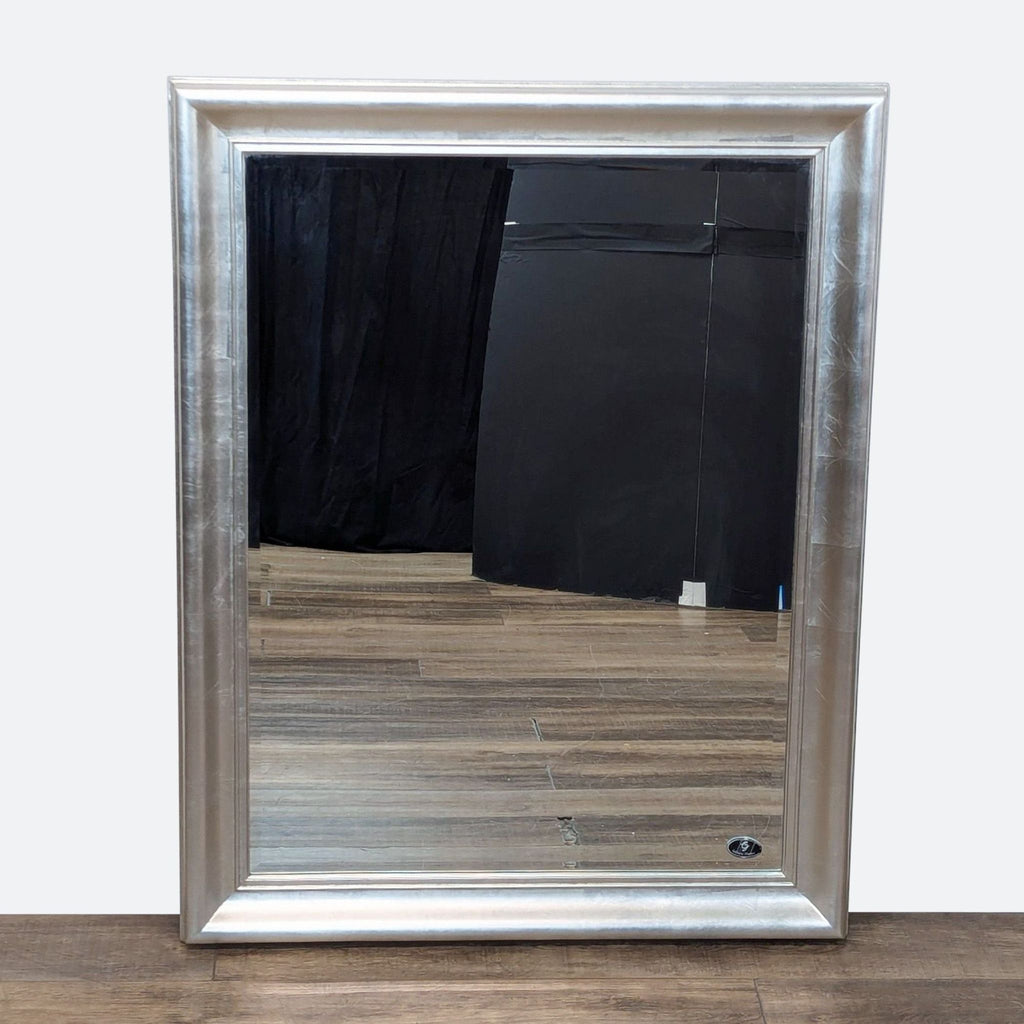 a large silver framed mirror with a mirror.