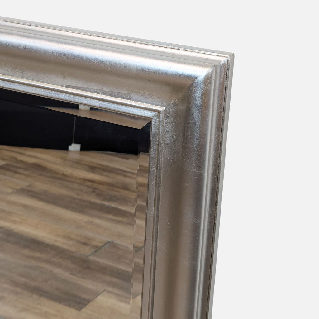 a large silver framed mirror with a white frame.