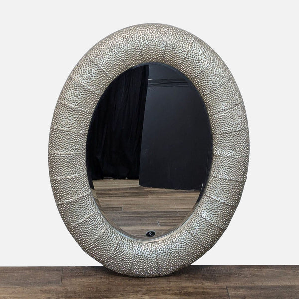 a large silver and gold oval mirror with a white frame.