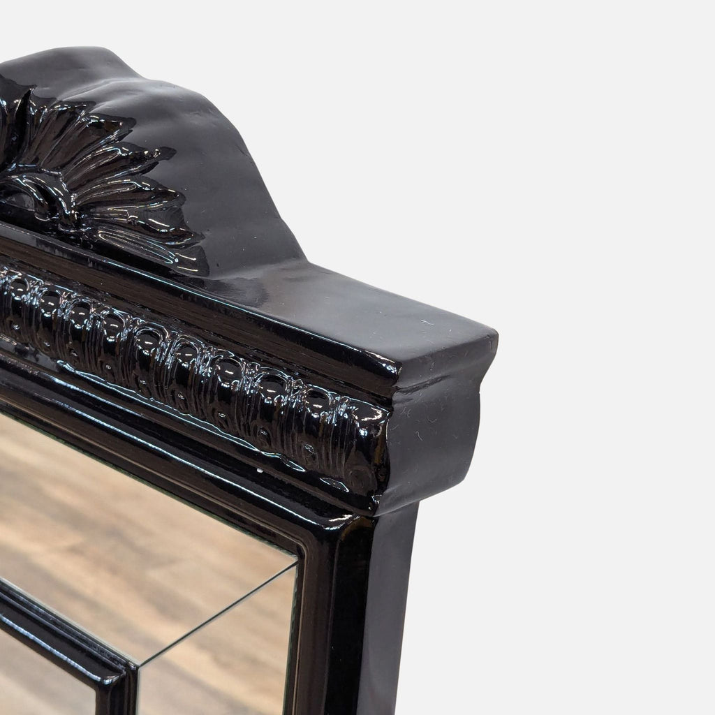 a black lacquer mirror with a carved floral design