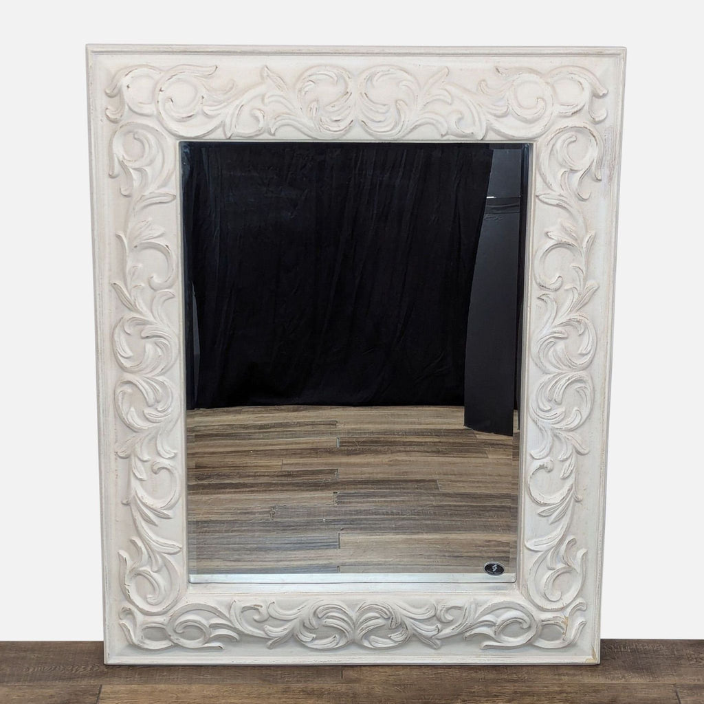 a large white carved stone mirror with a carved floral design.