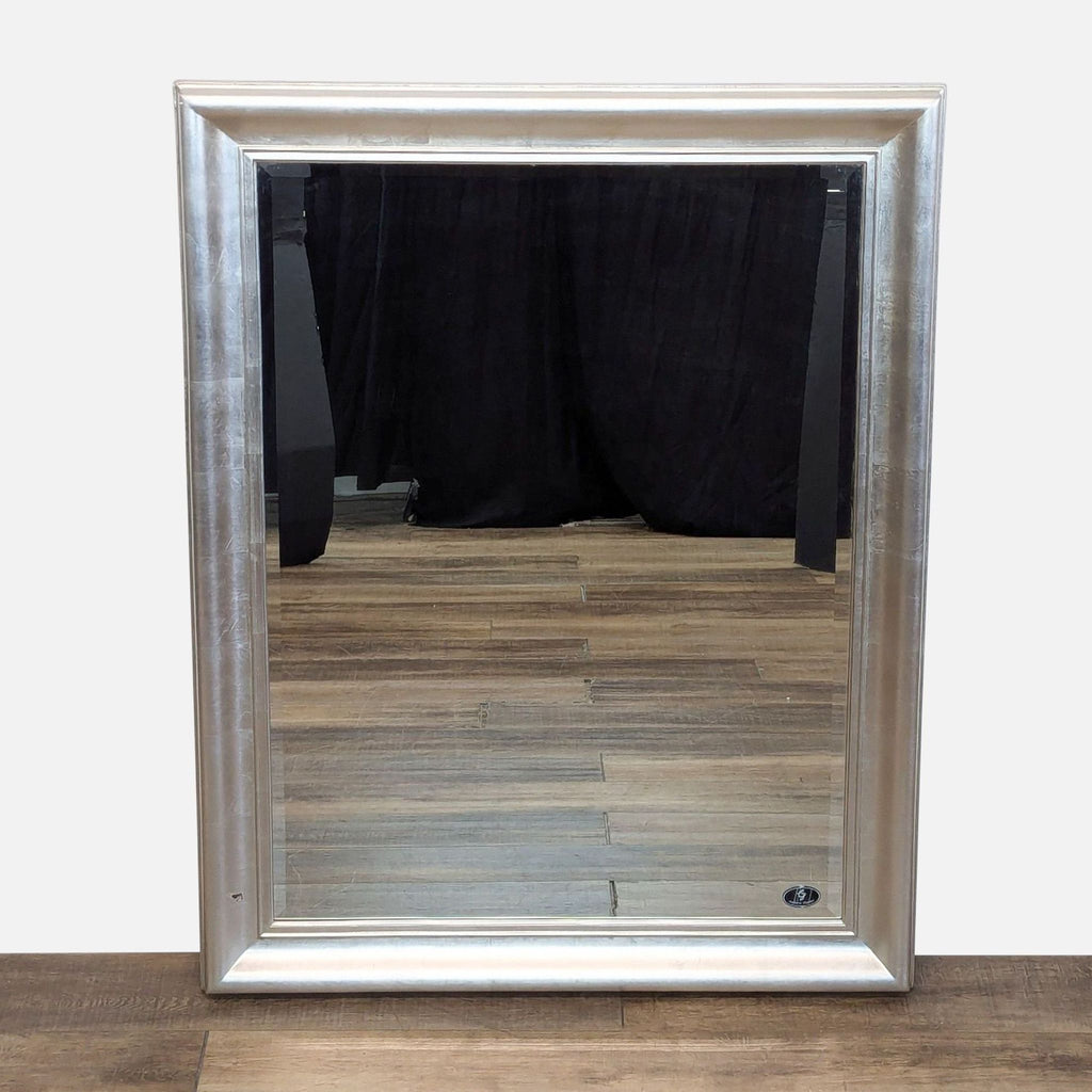 a large silver framed mirror with a mirror.