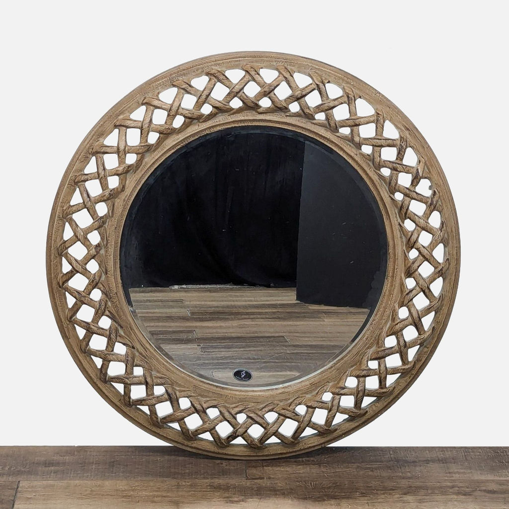 a round mirror with a carved wood frame.