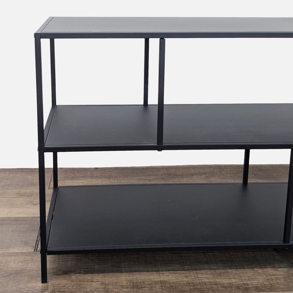 a black metal shelf with three shelves.