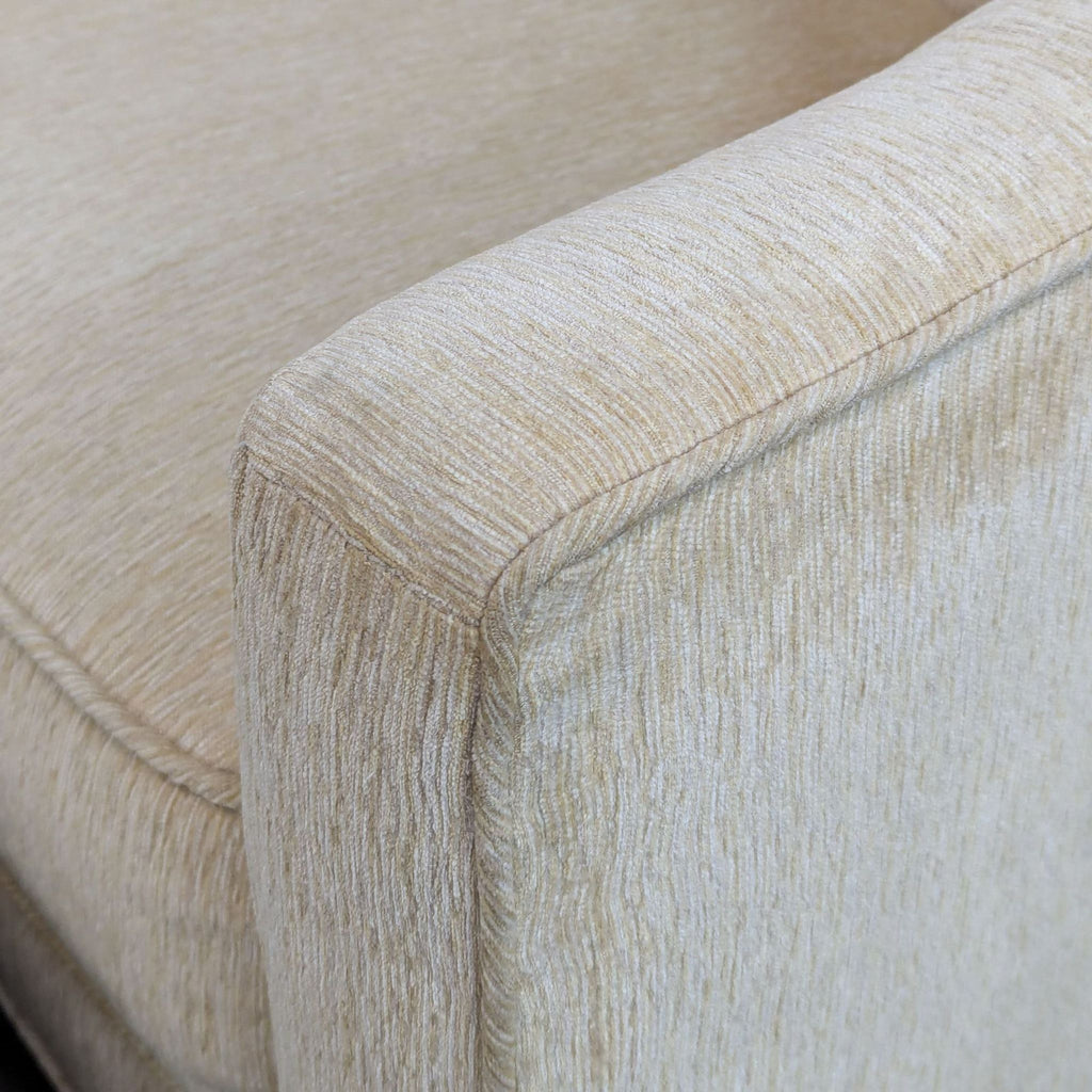 close up of the arm of a cream colored sofa.