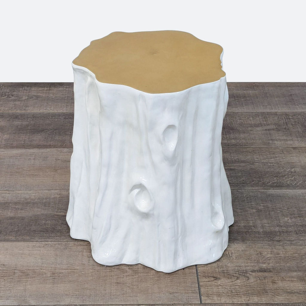 a white tree stump with a gold base.