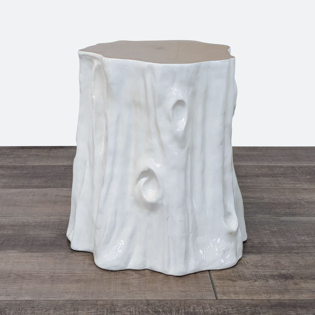 a white ceramic stool with a tree stump base.