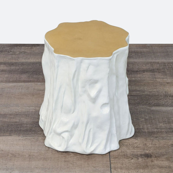 a white stool with a gold base.