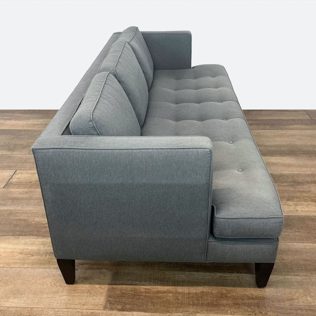 Modern 3-seater sofa from Room & Board featuring tufted bench seat and sleek wooden tapered legs.