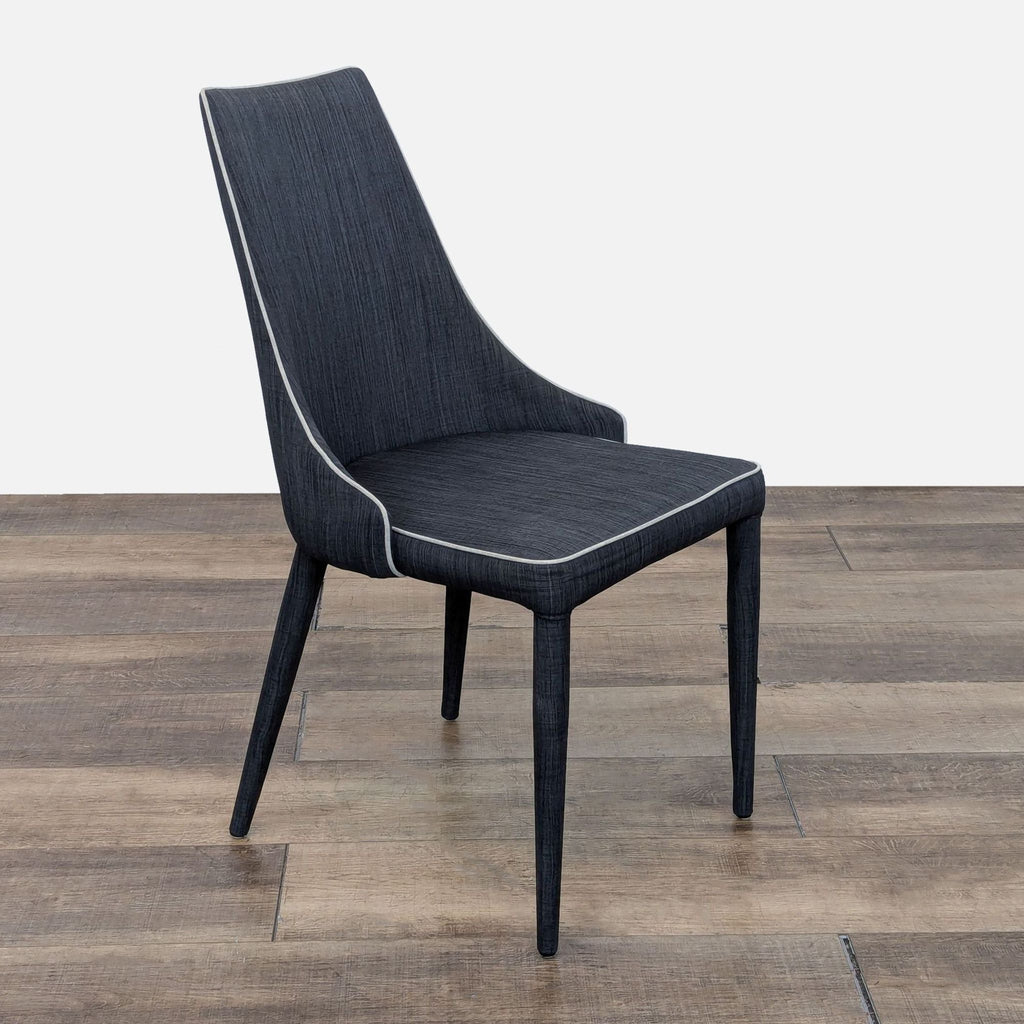 the chair is made of a dark grey fabric with a white stitching.