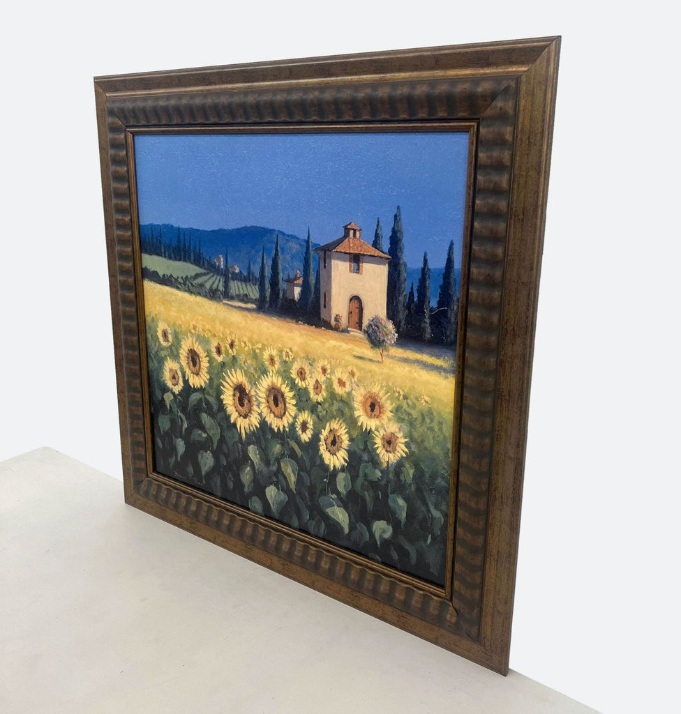 framed oil painting of a sunflower field with a church in the background