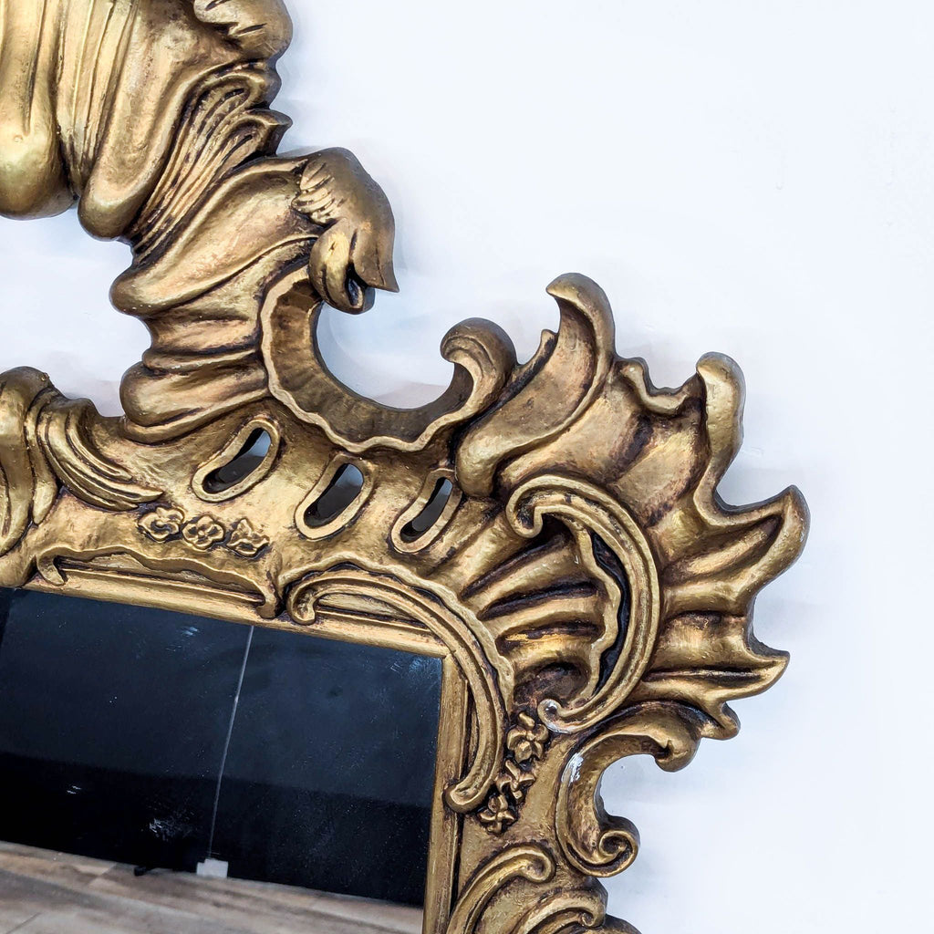 a large gold framed mirror with a dragon motif.