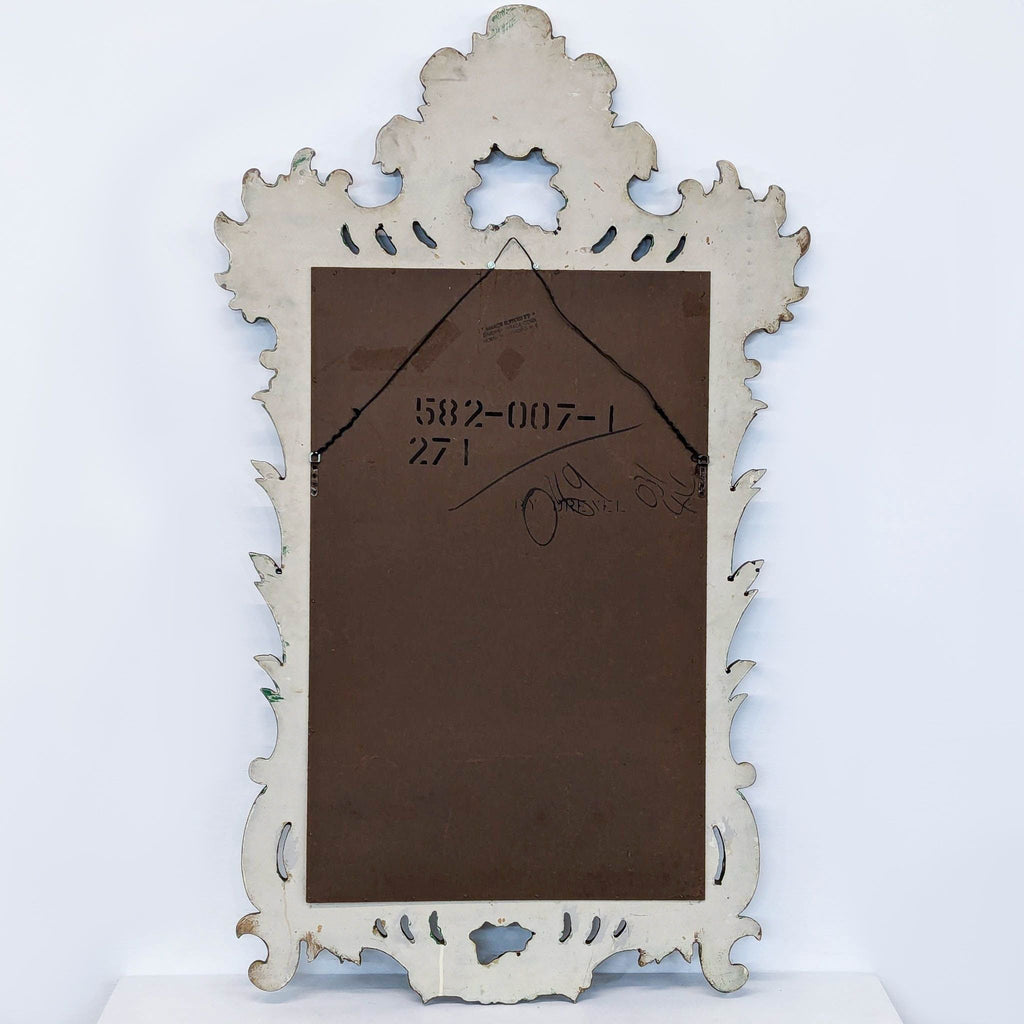 a mirror with a white frame and a brown base.