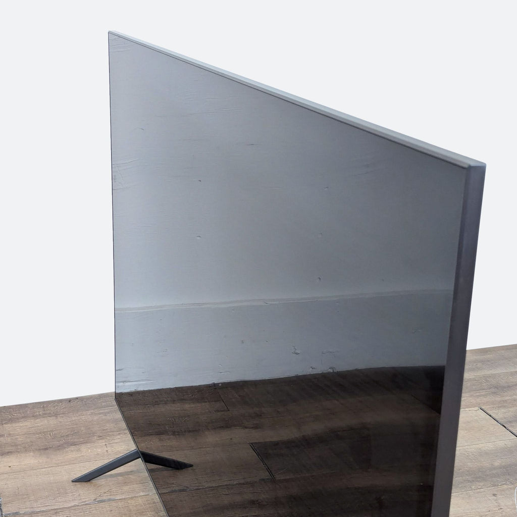 a large black glass tv stand with a white base.