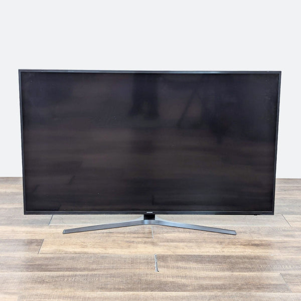 a large flat screen tv on a wooden floor.