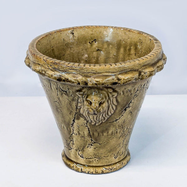 a large vintage cast iron planter with a lion head.