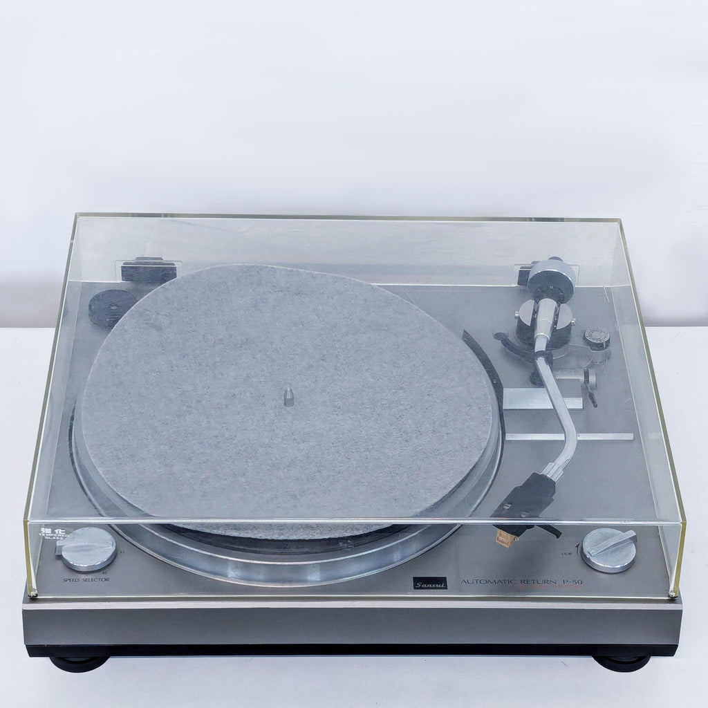 a vintage record player with a glass cover.