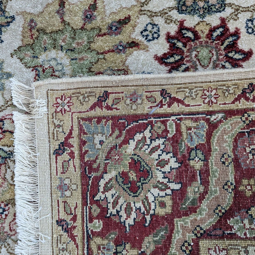 a close up of a carpet with a tassel