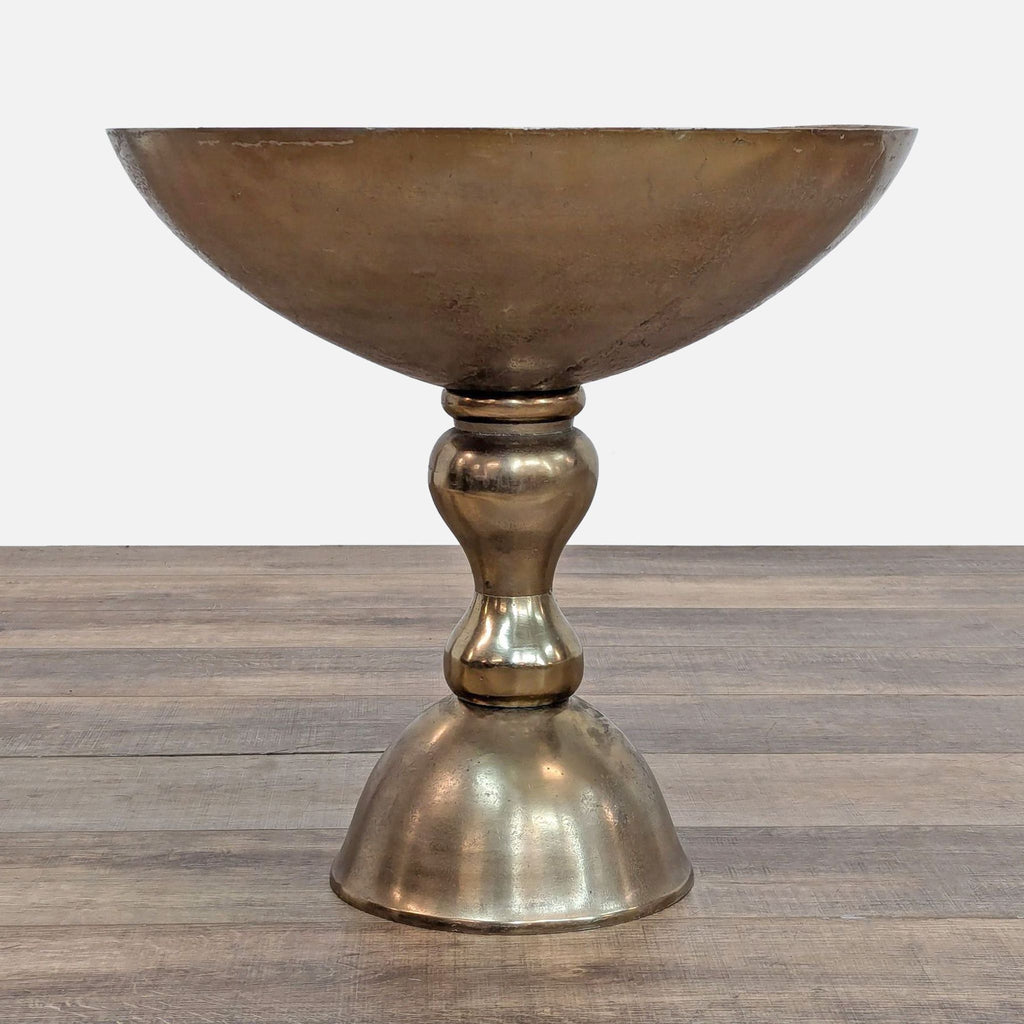 a brass wine glass with a round base.