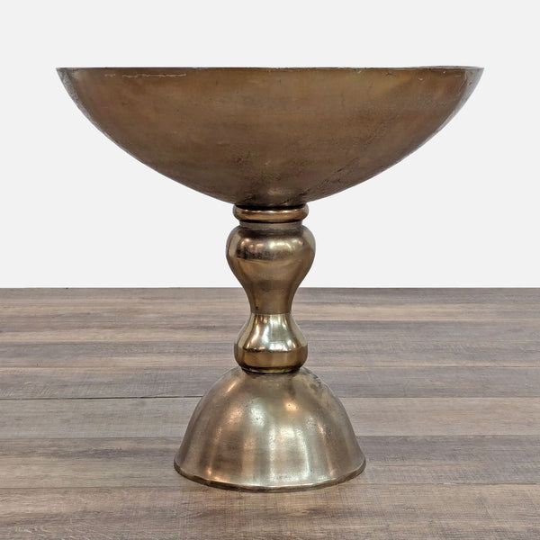 a brass wine glass with a round base.