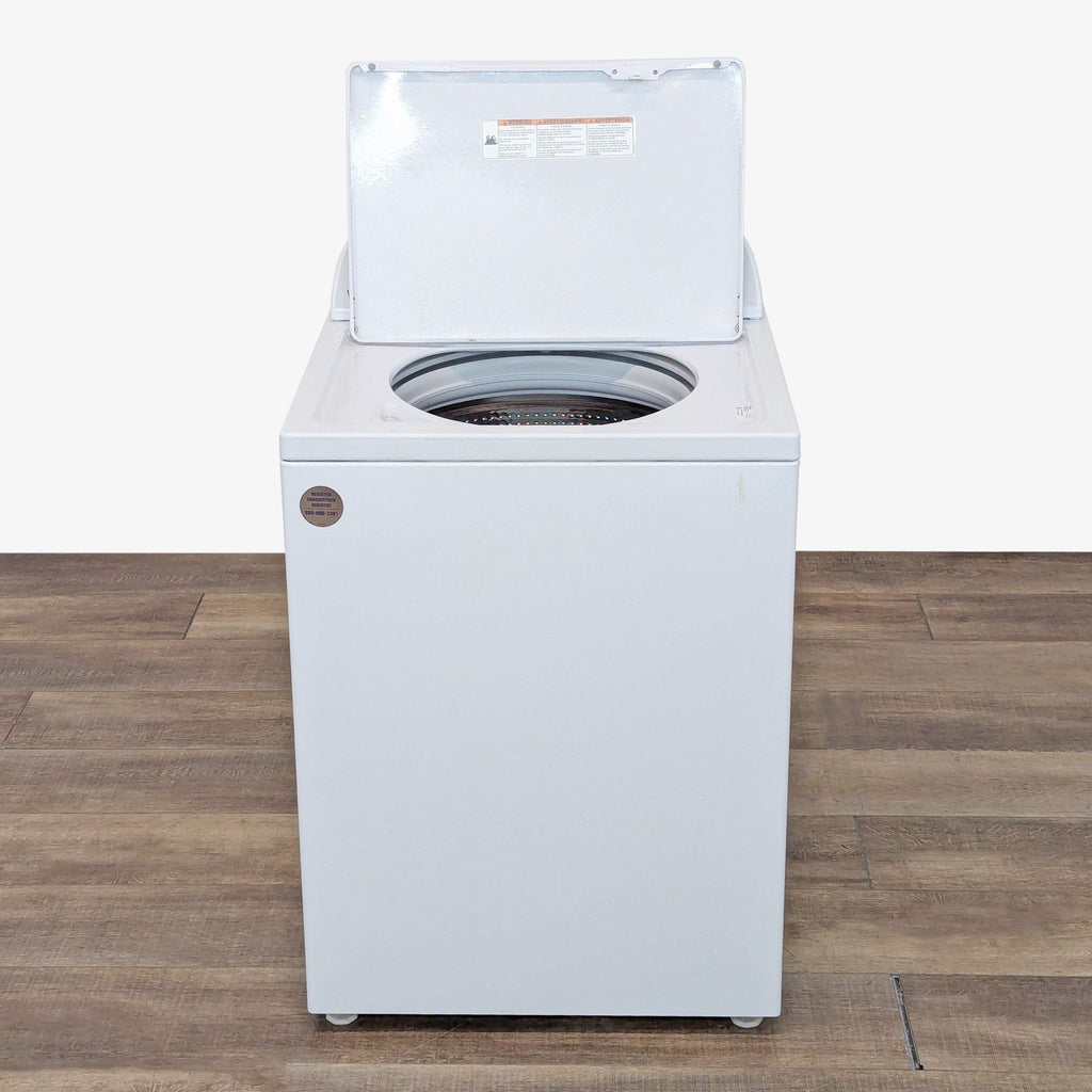 a white washing machine with a door open on a wooden floor.