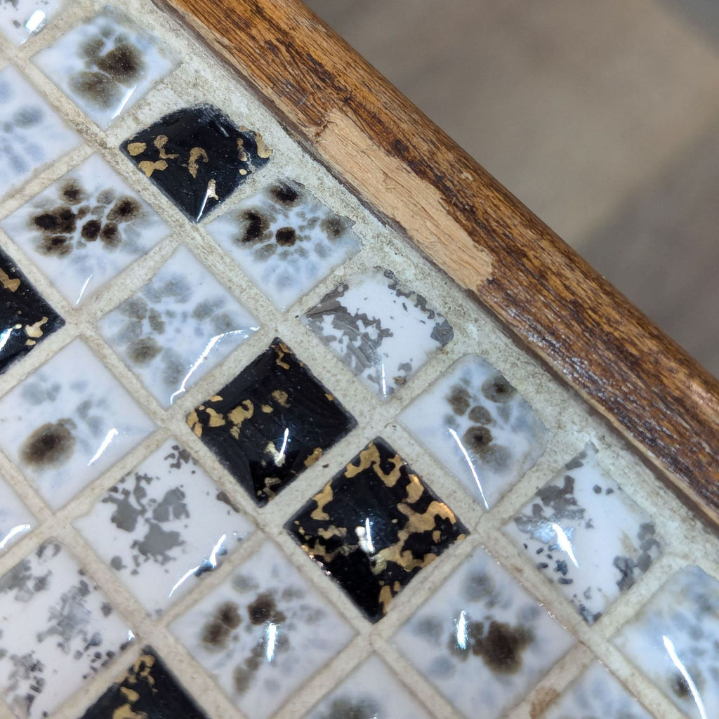 a close up of a table with a glass tile with black and white flowers.