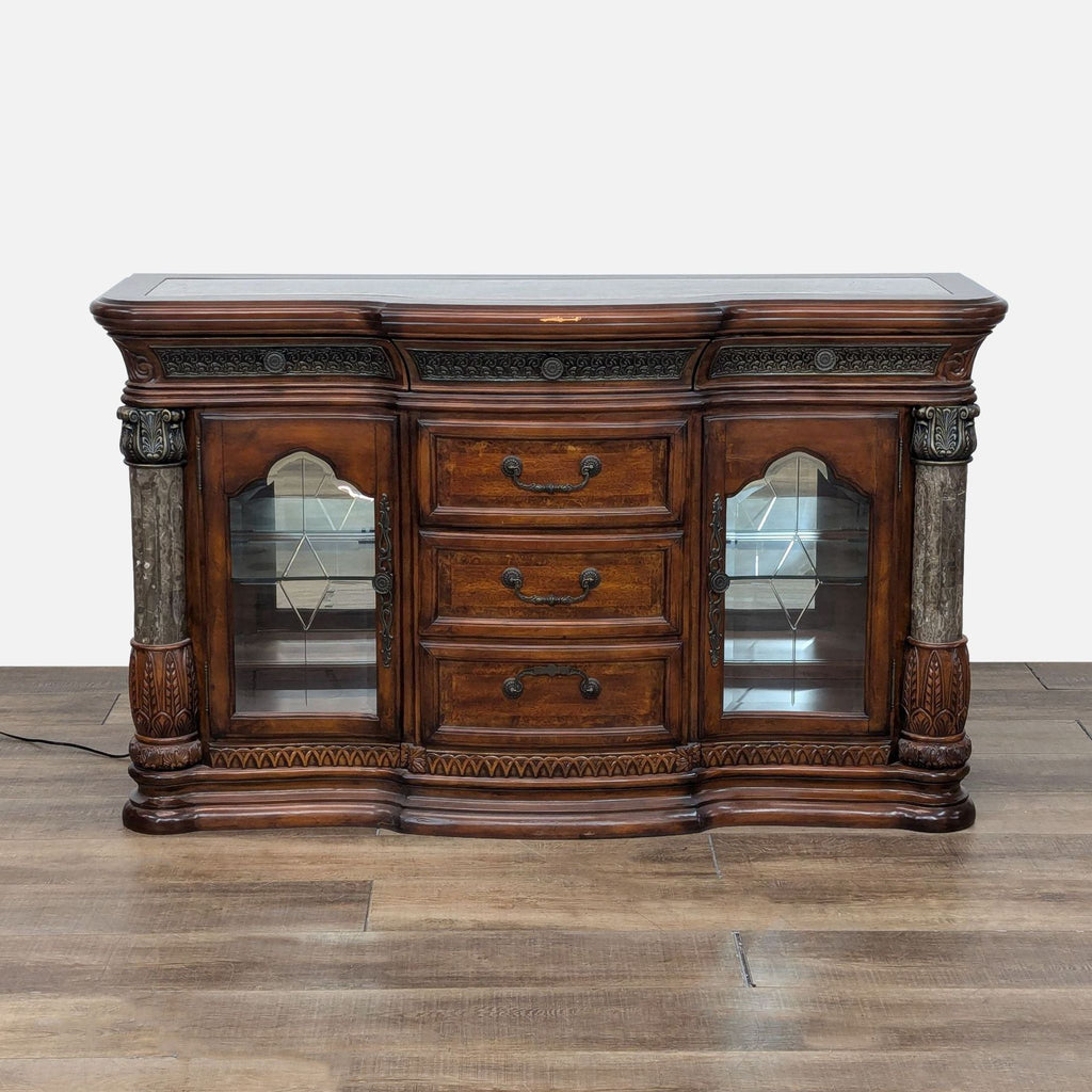 a large antique mahogany sideboard with glass doors and a drawer.