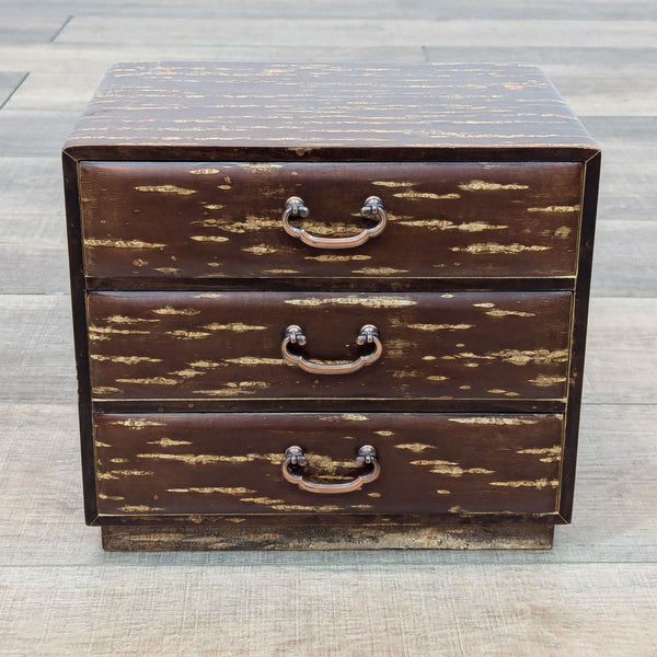 a small wooden chest with three drawers.