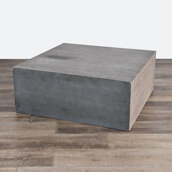 the coffee table is made from concrete and has a concrete finish.