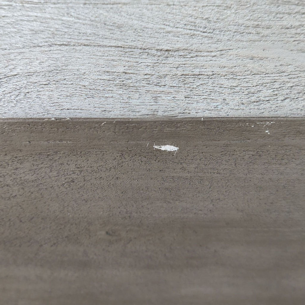 a close up of a wood table with a white paint stain on it.